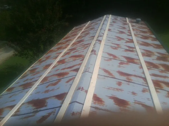 Rusted metal roof panels with new wood purlins before replacement — Storm Damage Roof Repair in Gary by Roofing Brothers