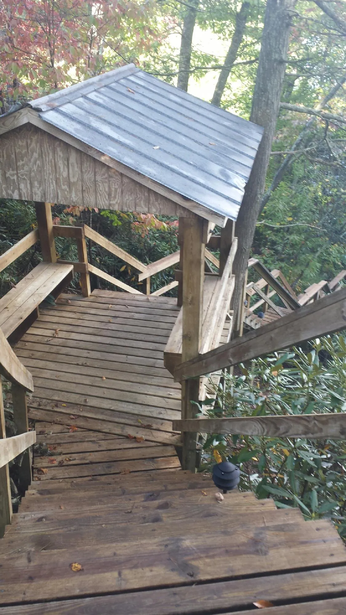 Metal roofed shelter over wooden steps on a wooded walkway — Skylight Repair & Installation work by our crew in Gary
