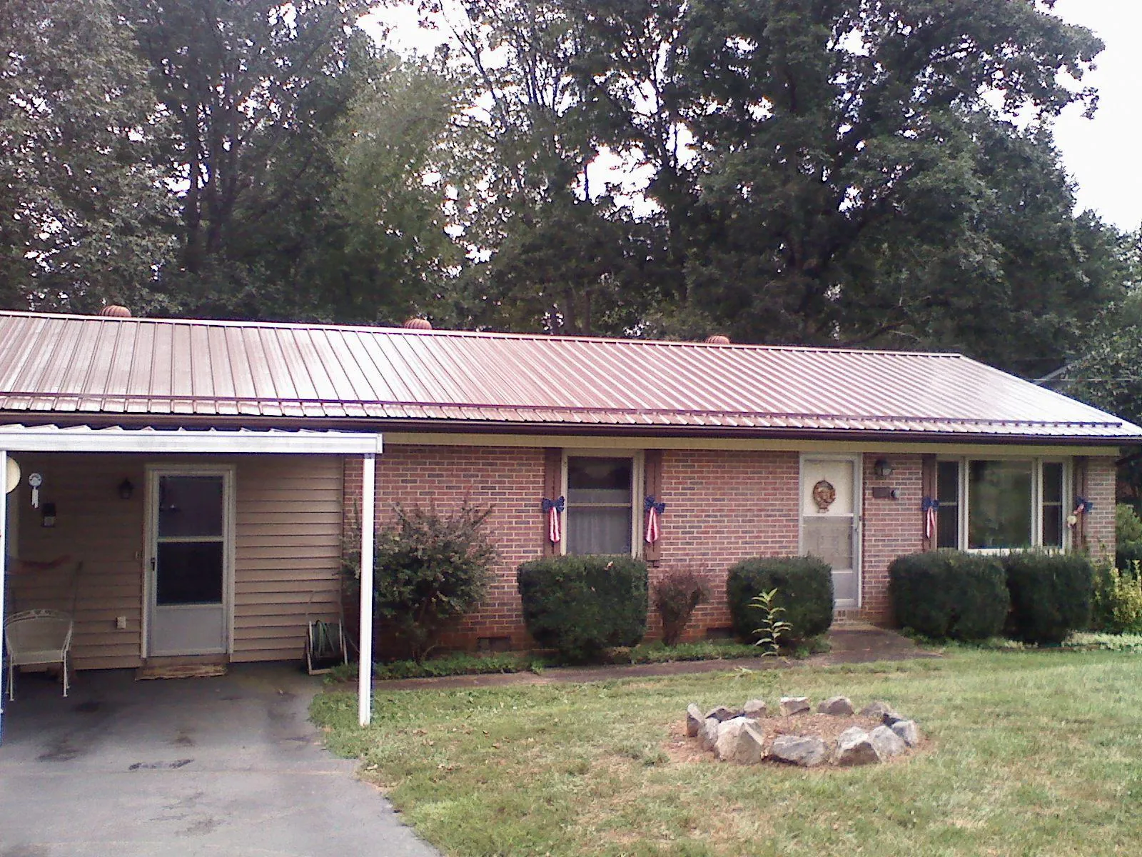 Bronze metal roof and carport on a brick ranch home — Roof Repair work by our crew in Gary