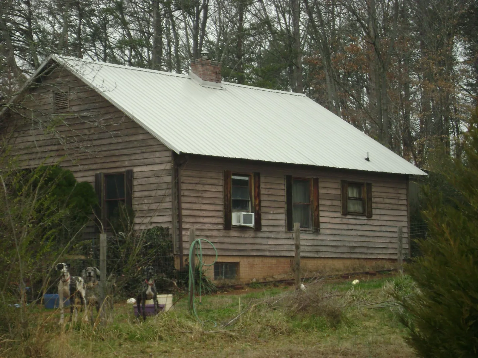 White metal roof on an old wood sided farmhouse, from a Metal Roof Installation job in Gary